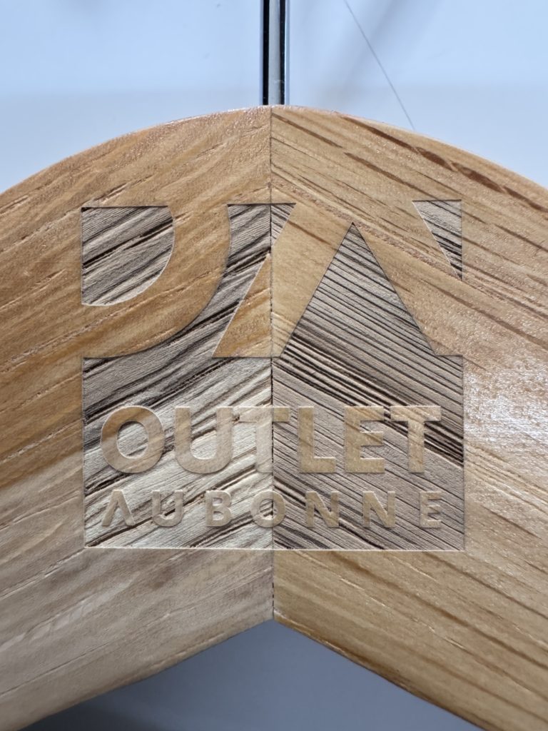 Gravure laser sur un cintre le logo de l'outlet d'aubonne